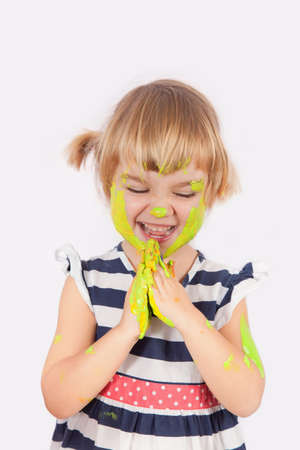 Small girl with paint on her cheek and nose isolated on grey
の写真素材