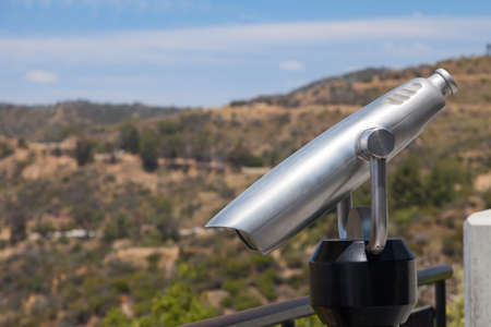 Spyglass and nature landscape with the hills and blue sky