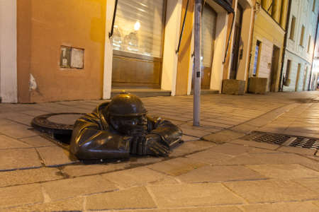 Sewage worker statue on the night street in Bratislava, Slovakiaの写真素材
