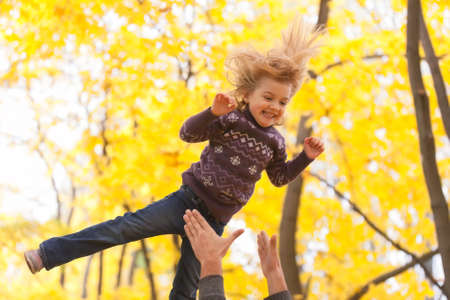 Cute little girl jumping in the autumn forest