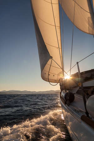 Sailboat crop during the regatta at sunset ocean