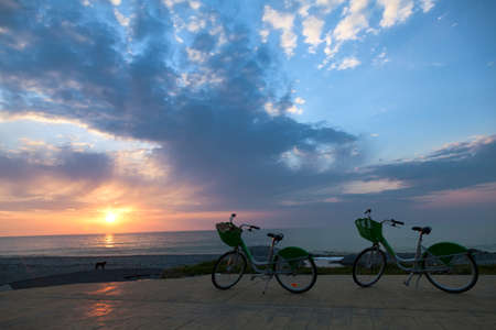 Two bicycles on Batumi beach, sunsetの写真素材