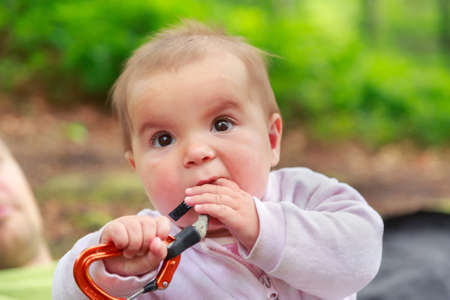 Baby girl eating climbing equipment quickdrawの写真素材