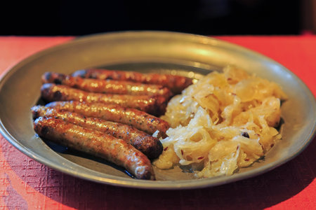 Nuremberg sausages with cabbage and spices on metal plateの写真素材