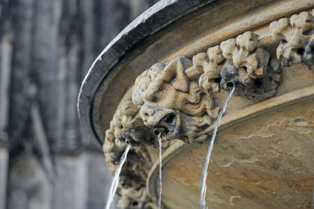 Ugly demon statue with streaming water from mouth near Cologne cathedral, Germanyの写真素材