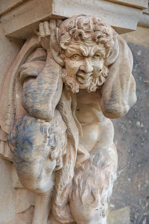 Closeup half faunus statue under column 