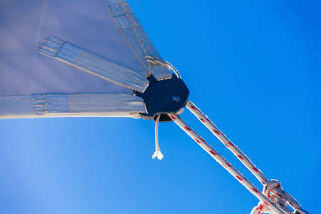 rope, knot and piece of sail isolated on blue on sailing boatの写真素材