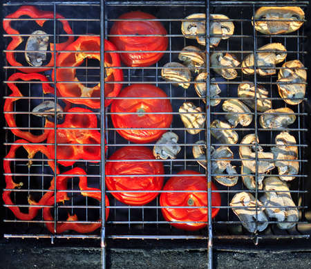 Red grilled pepper, tomato and mushrooms on bbq fireplaceの写真素材