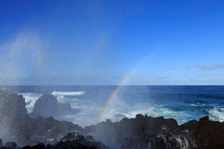 Wave splash with rainbow on the rocks, Azores, Portugalの写真素材