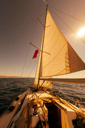 Sailing boat wide angle view in the sea at sunset, instagram toning