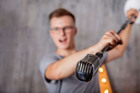 Young man singing with vintage microphoneの写真素材