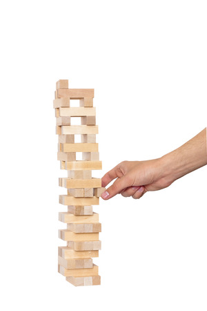 Hand playing in jenga on white backgroundの写真素材