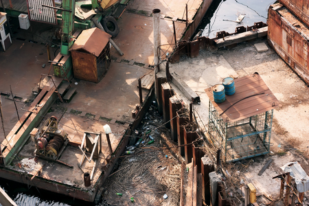 Rusty barge in a dirty portの写真素材