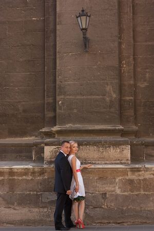 Wedding couple standing near the wall with beautiful old lanternの写真素材