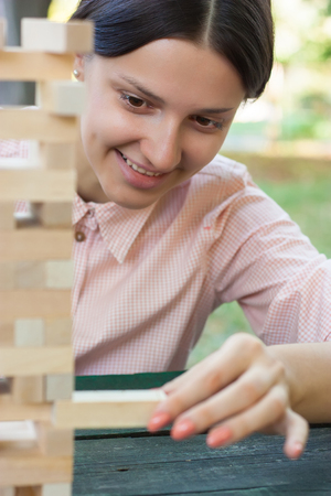 Smiling girl is playing a wooden block game in the park.close upの写真素材