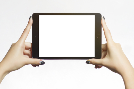 Happy young woman using digital tablet. Happy young student with eyeglasses is watching a movie on tablet. Female student is studying on a tablet at home.の写真素材