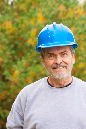 Contractor Builder with blue hardhat smiling