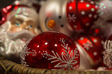 Beautiful red and white christmas tree decorations shaped like santa claus and a smiling snowman with wool capの写真素材