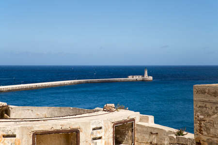 View on a lighthouse over the walls of an ancient fortress in Valletta on Malta.の写真素材
