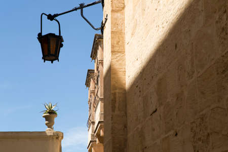 View on a street lamp and typical balconies in the historical medieval city of Mdina on Maltaの写真素材