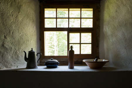 View on several vintage household items standing close a somber window sill.の写真素材