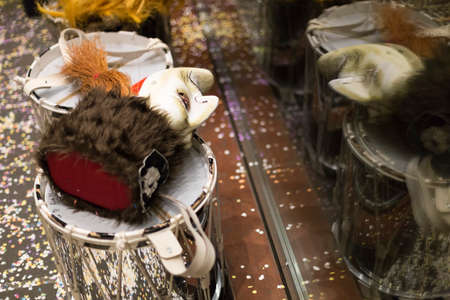 Some snare drums with masks laying on top during the basel carnival. One mask reflects in the window of a nearby shop. Picture taken on 15th of February 2016 in Basel, Switzerlandのeditorial素材