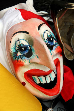 A single mask resting on the ground during the basel carnival 2011, showing a smiling clown.の写真素材