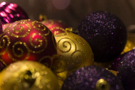 Beautiful red, gold and purple christmas tree balls with golden glitter decorationの写真素材