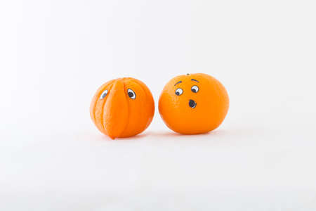 Fresh oranges with funny faces in front of white background. One orange has a huge noseの写真素材