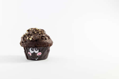 A fresh and sweet chocolate muffin with cute cartoon style face on white backgroundの写真素材