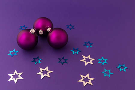 Beautiful purple christmas balls with satin effect and metallic silver and blue stars on purple background.の写真素材