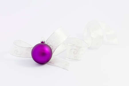 Beautiful glossy purple christmas balls with white and silver ribbon on white backgroundの写真素材