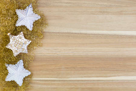 Beautiful white and gold christmas decoration on gold glitter and wood background.の写真素材