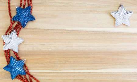 Beautiful white, red and blue christmas decoration with red ribbons on wood background.