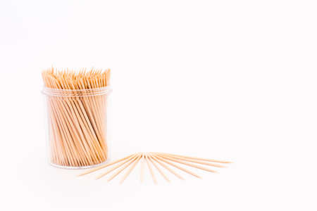Wooden toothpicks in a transparent plastic container on white backgroundの写真素材