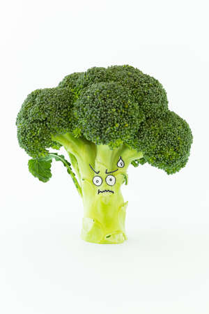 Closeup of fresh green broccoli with scared cartoon style face on white backgroundの写真素材