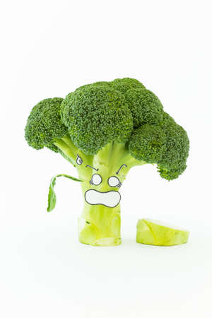 Closeup of fresh green broccoli with scared cartoon style face on white backgroundの写真素材