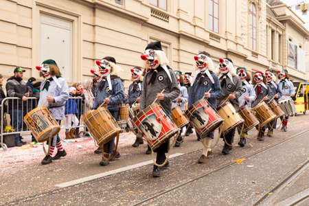 Steinenberg, Basel, Switzerland - February 19th, 2018. A group of carnival participants in colorful costumes playing snare drumsのeditorial素材