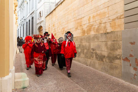 Basel carnival. Rheinsprung, Basel, Switzerland - February 21st, 2018. Group of revelers in red costumes in the old townのeditorial素材