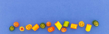Assortment of colorful sweet handmade candy pieces arranged on blue paperの写真素材