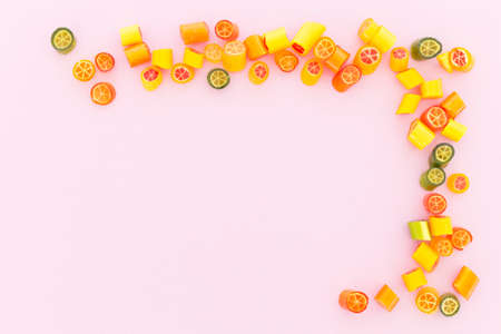 Assortment of colorful sweet handmade candy pieces arranged on light pink paper