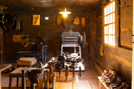 Ballenberg, Brienz, Switzerland, April 14th 2018. View into a small traditional shoemaker workshop with craft tools, equipment, materials and finished pairs of heavy leather shoes.のeditorial素材