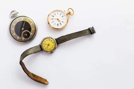 Set of watches on white background with a classic gold pocket watch a black and silver pocket watch...