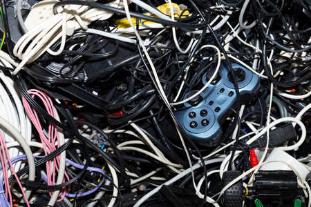 Close-up of an entangled heap of electronic scrap including a game console controller waiting for recyclingの写真素材