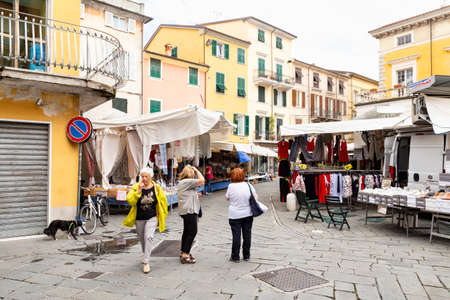 Italy, Liguria, La Spezia, Sarzana, Via Antonio Gramsci 8-10. 14th of June 2018. A street of the old town with market stands mostly selling clothes, shoes and handbags.のeditorial素材