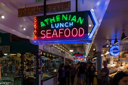 United States of America, USA, Seattle, Washington, Pike Place, May 10th 2019. Illuminated advertisement above a public market stand with fresh seafood.のeditorial素材