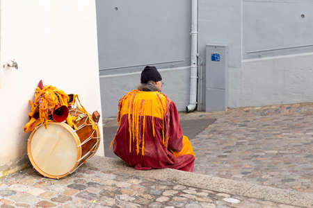 Martinskirchplatz, Basel, Switzerland - March 12th, 2019. Single carnival participant with orange costume and a snare drumのeditorial素材