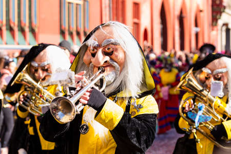 Marktplatz, Basel, Switzerland - March 13th, 2019. Close-up of a carnival participant in a yellow and black costume playing trumpetのeditorial素材