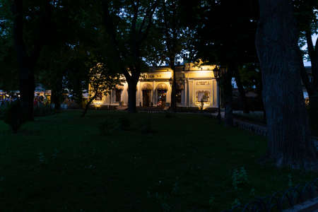 Ukraine, Odessa, Deribasivska Street, 11th of June 2019. View on the old and beautiful Odessa cafe building in the city garden at sunset.のeditorial素材