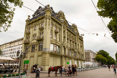 Ukraine, Odessa, Deribasivska Street, 13th of June 2019. Impressive historical green building with statues and stucco decorations.のeditorial素材